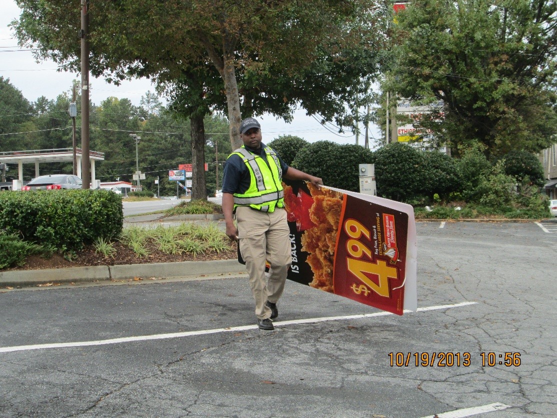 Code Enforcement removes an illegal sign during a recent sign sweep.